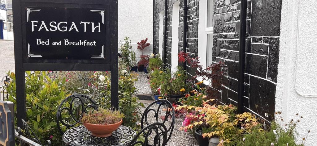 un jardín con plantas y bancos y un cartel en Fasgath B&B, en Kyle of Lochalsh