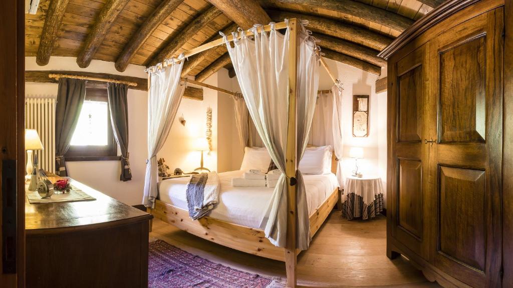 1 dormitorio con cama con dosel en una habitación en Revivre Village Adults only en Champorcher