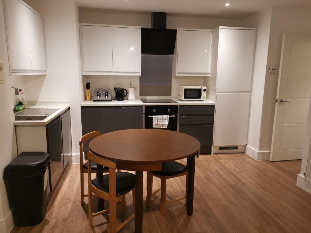 a kitchen with a wooden table and a small table and chairs at Miller Suite in Kent