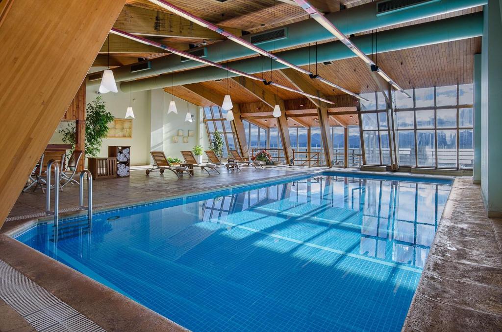 a large swimming pool with blue water in a building at NH Bariloche Edelweiss in San Carlos de Bariloche