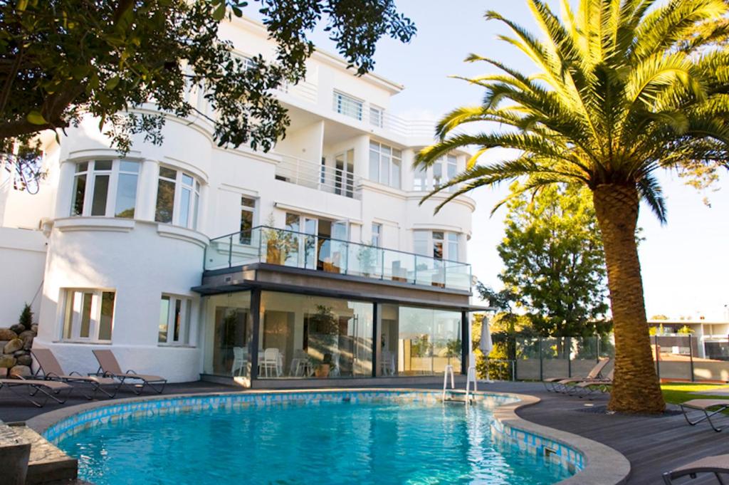 uma villa com piscina em frente a um edifício em Amazonia Estoril Hotel em Estoril