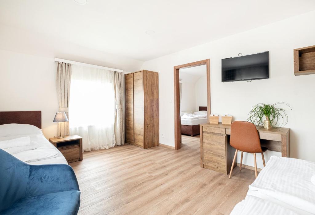 een slaapkamer met een bed en een bureau met een spiegel bij Hotel U Císaře in Mirošovice