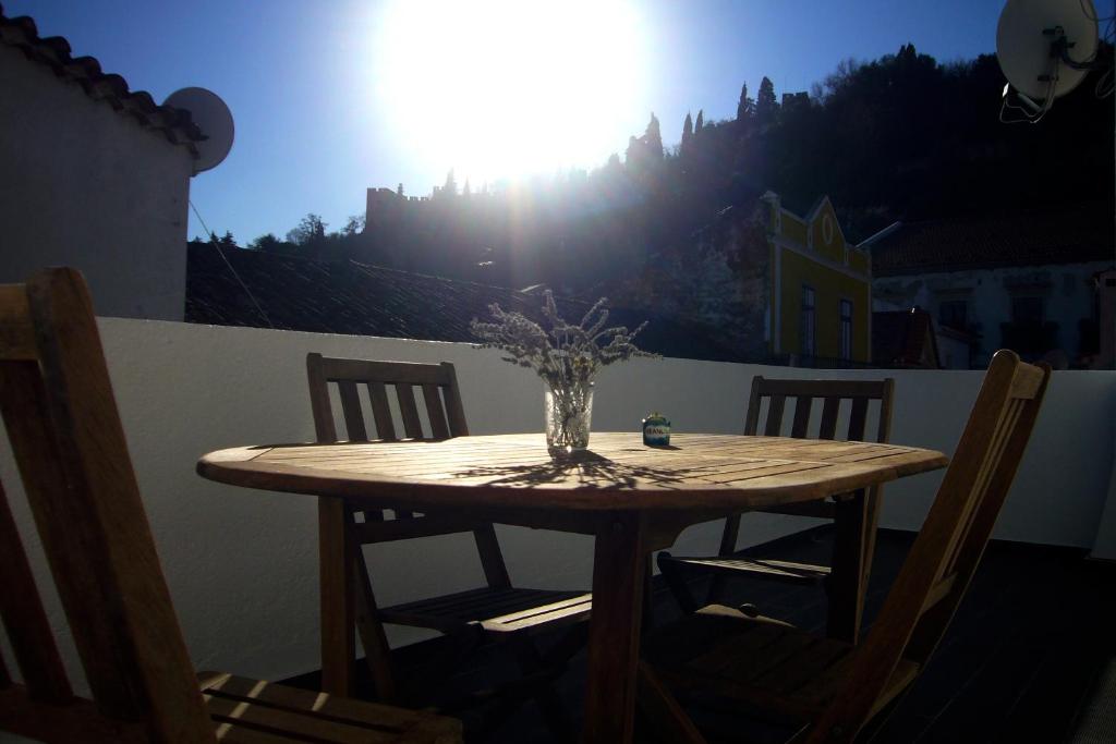 een houten tafel met een vaas met bloemen erop bij Castle, Terrace and Relax in Tomar