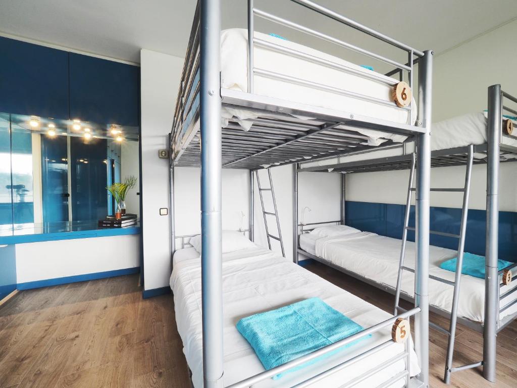 two bunk beds in a room with blue walls at Impact House Belém in Lisbon