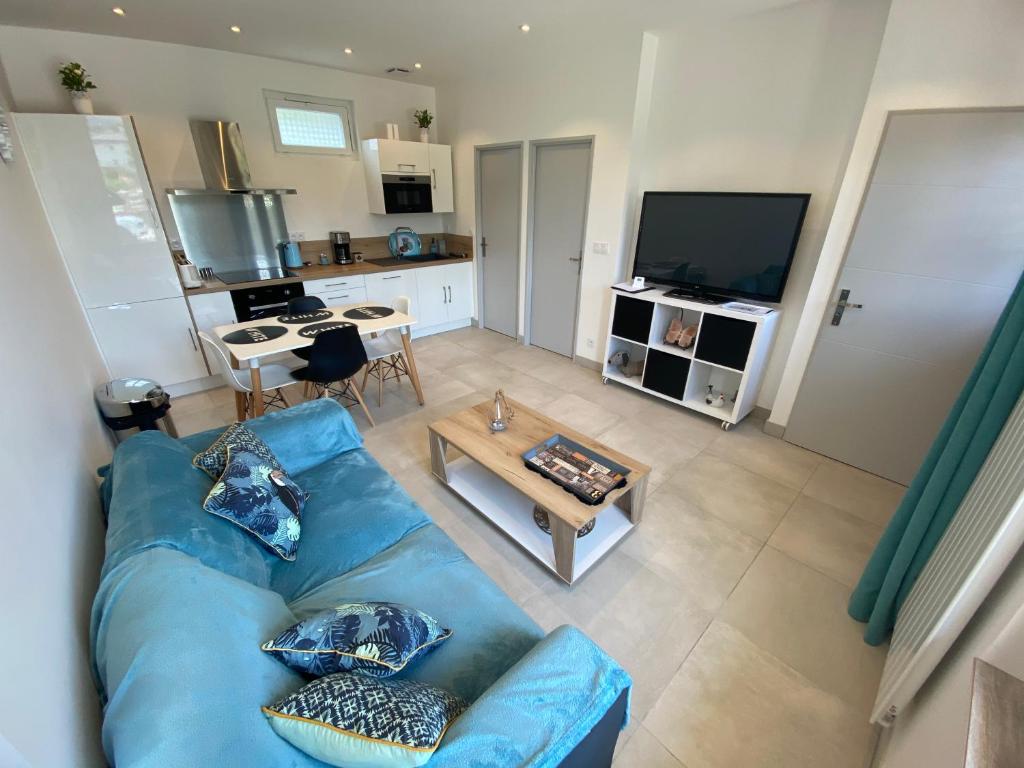 エクスレバンにあるLa Maison d’Aliceの青いソファとテーブルのあるリビングルーム