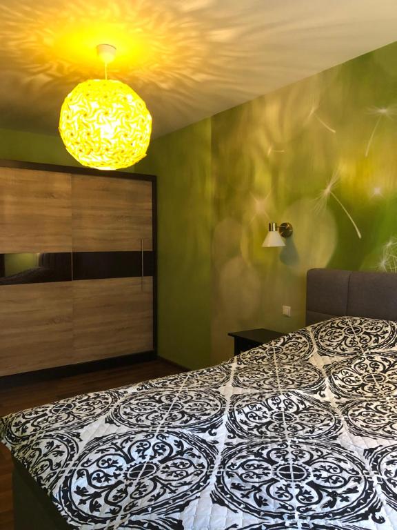 a bedroom with a bed and a yellow light at Green and quiet city center in Rīga