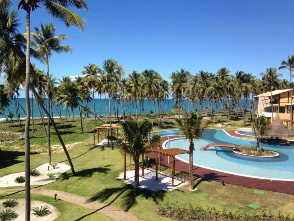 una vista aérea de un complejo con piscina y palmeras en Apt Coral Azul Iberostate Praia do Forte, en Praia do Forte