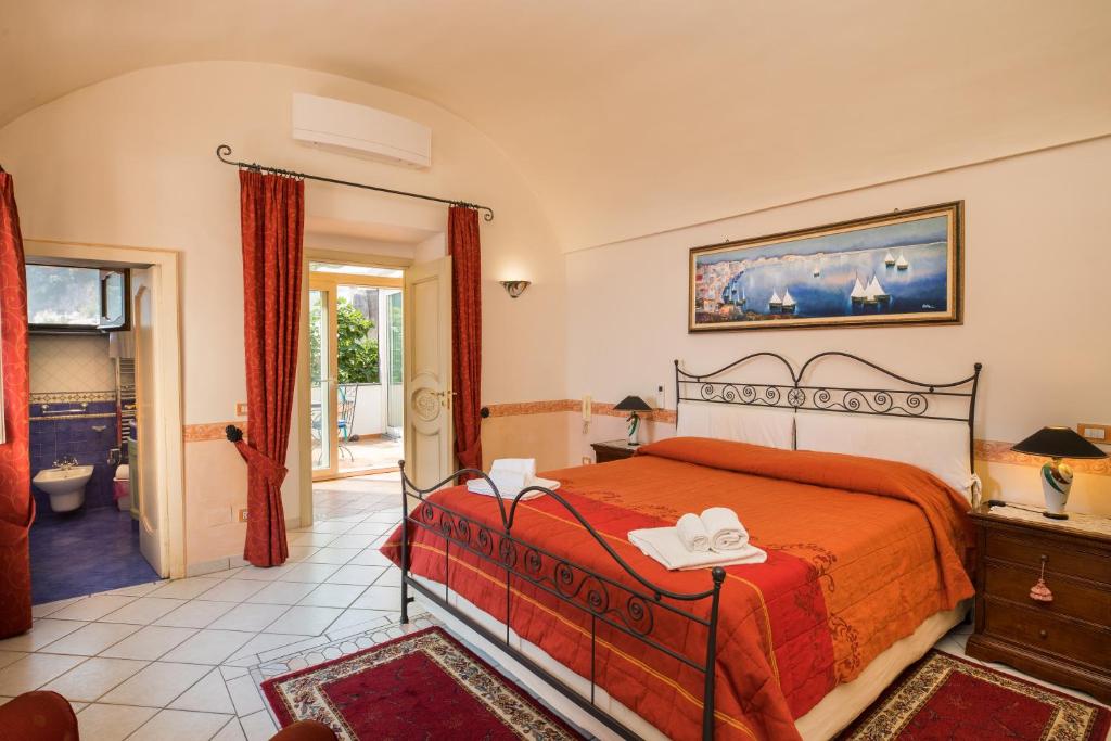 a bedroom with a bed with a orange bedspread at De Vivo Realty - Ilary House Positano in Positano