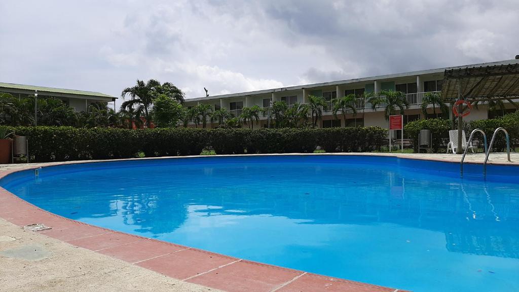 a large blue swimming pool in front of a building at Hotel parador tropical in Cartagena de Indias