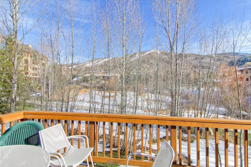 Una terraza con sillas y mesas y vista a la nieve. en Evergreens 03, en Steamboat Springs