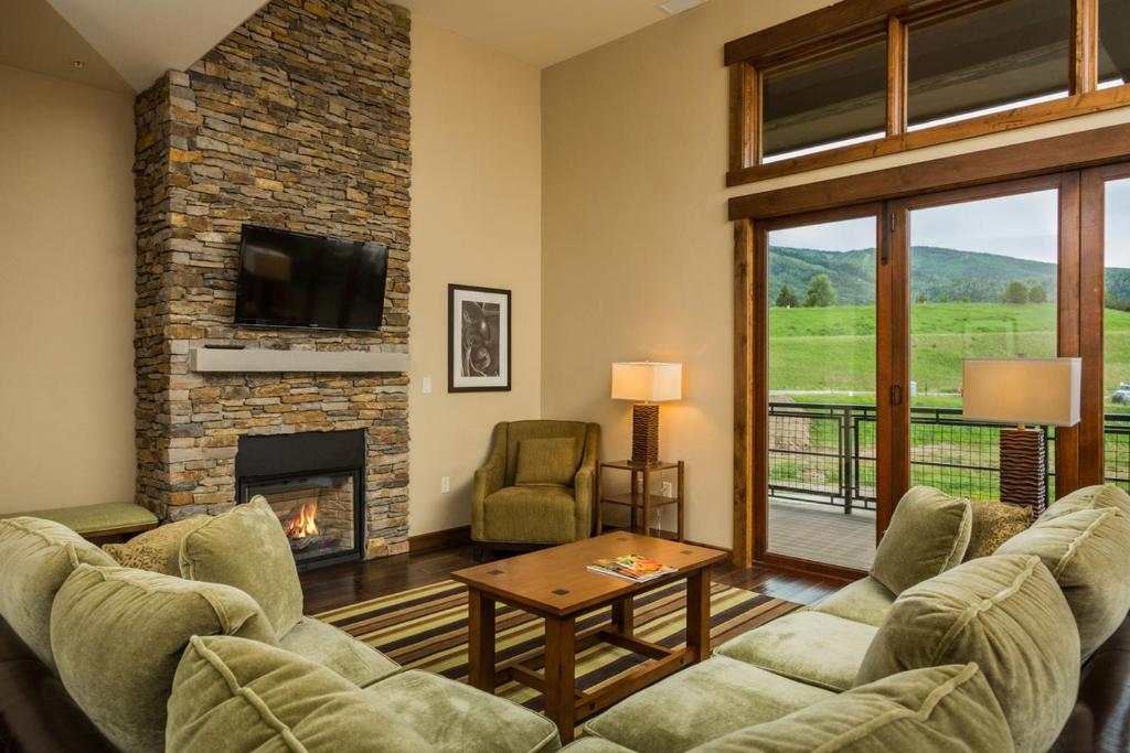 a living room with two couches and a fireplace at Trailhead Lodge 4100 in Steamboat Springs