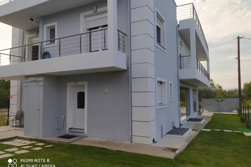Casa blanca con balcón y patio en Alykes Volos, en Volos