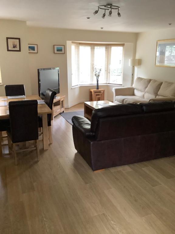 a living room with a couch and a table at Simpson's Apartments Rugby Ltd in Rugby