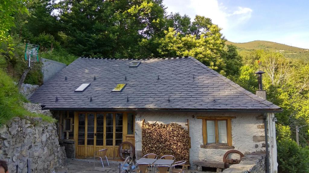 a small house with a roof and some chairs at El oso burlón in La Viliella