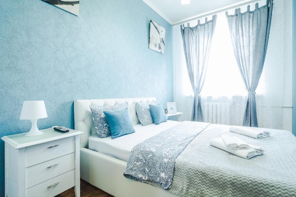 モスクワにあるRiverside Premium Class Apartmentのベッドルーム1室(青い壁のベッド1台、窓付)