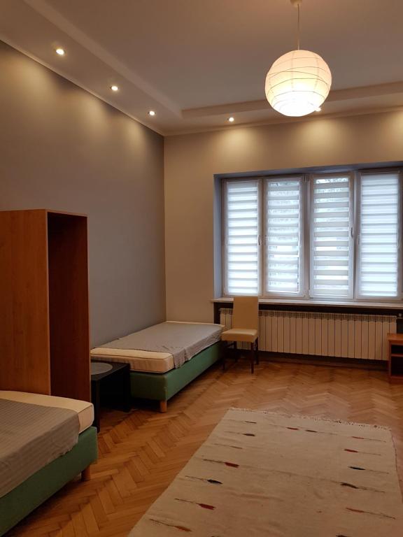 a bedroom with two beds and a large window at Center Rooms in Jarosław