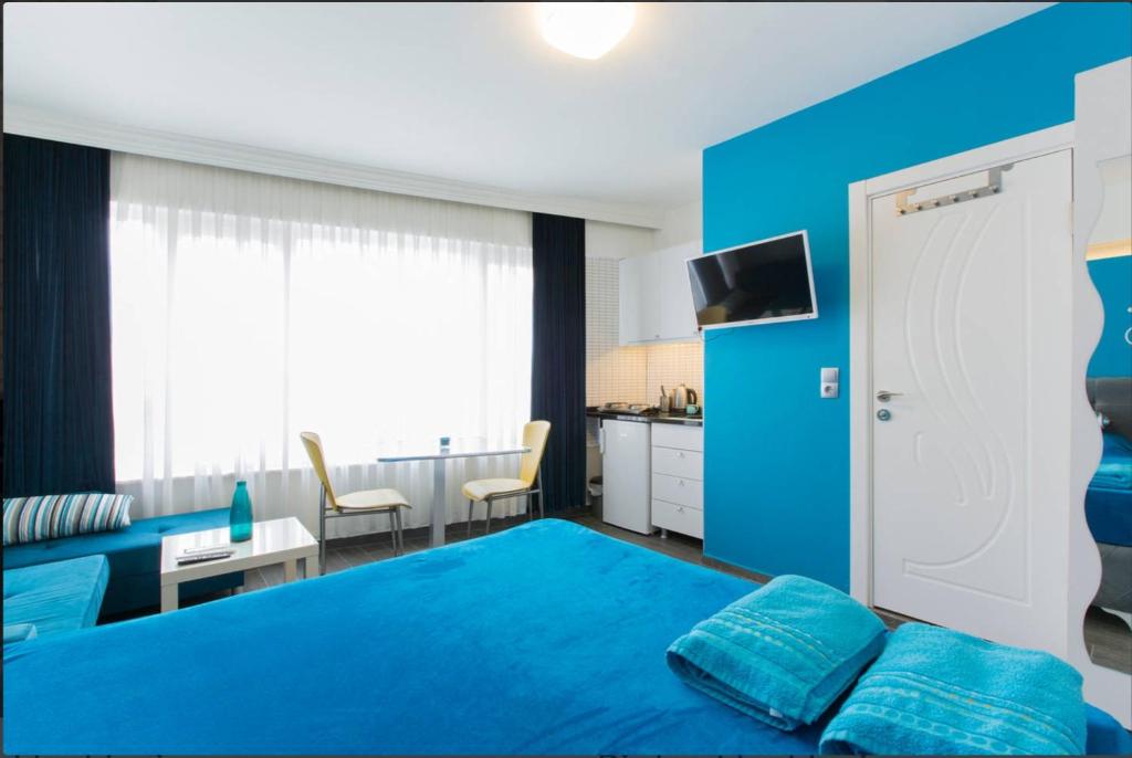 une chambre bleue avec un lit bleu et une cuisine dans l'établissement Blue Apartments, à Istanbul