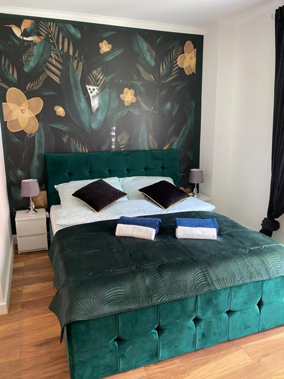 a green tufted bed in a bedroom at Apartament MATEO in Malbork