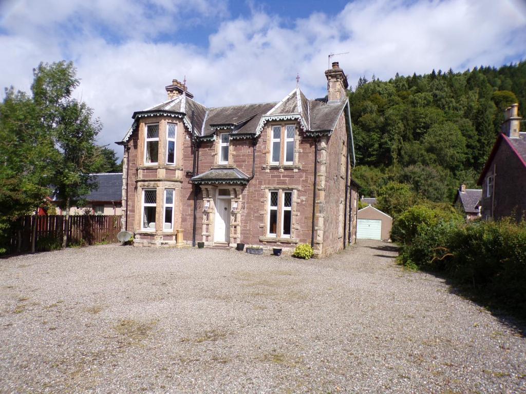 an old brick house with a large driveway at Dunmor House - Charming Victorian Period Property in Callander
