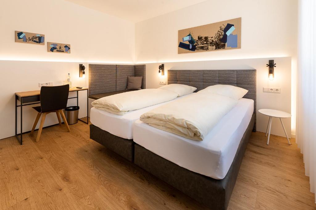SüdlohnにあるHotel & Gasthaus Nagelのベッド2台とデスクが備わるホテルルームです。