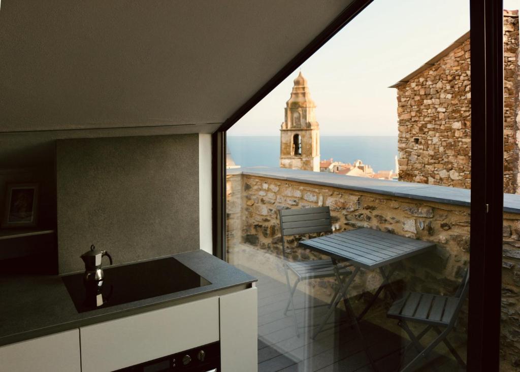 uma cozinha com um lavatório e uma mesa numa varanda em La Casa Giusta - Domus Ista em Cipressa