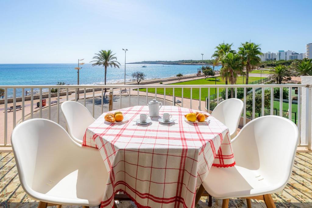 einen Tisch und Stühle mit Meerblick in der Unterkunft Skyline Cala Nau in Cala Millor