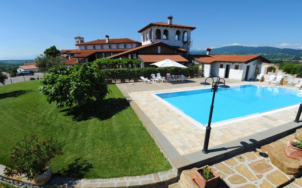 a swimming pool in a yard next to a house at Belica Bed and Breakfast in Dobrovo