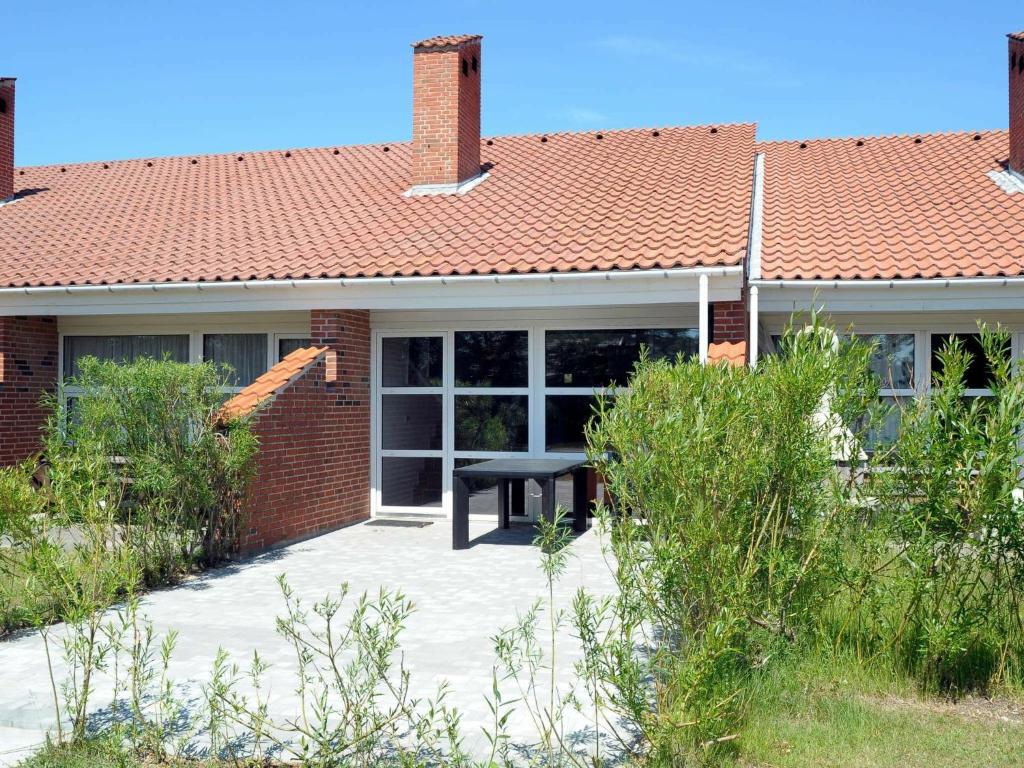 ein Backsteinhaus mit einem Picknicktisch im Vorgarten in der Unterkunft 6 person holiday home in Bl vand in Blåvand