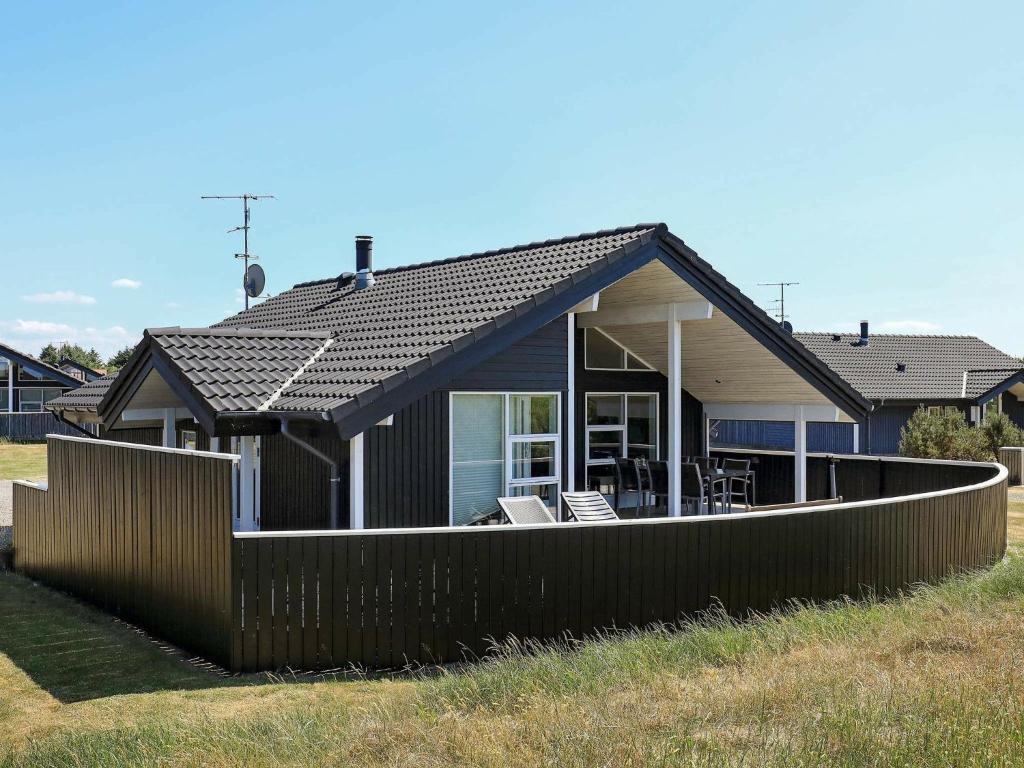 een huis met een hek ervoor bij 6 person holiday home in Ringk bing in Søndervig