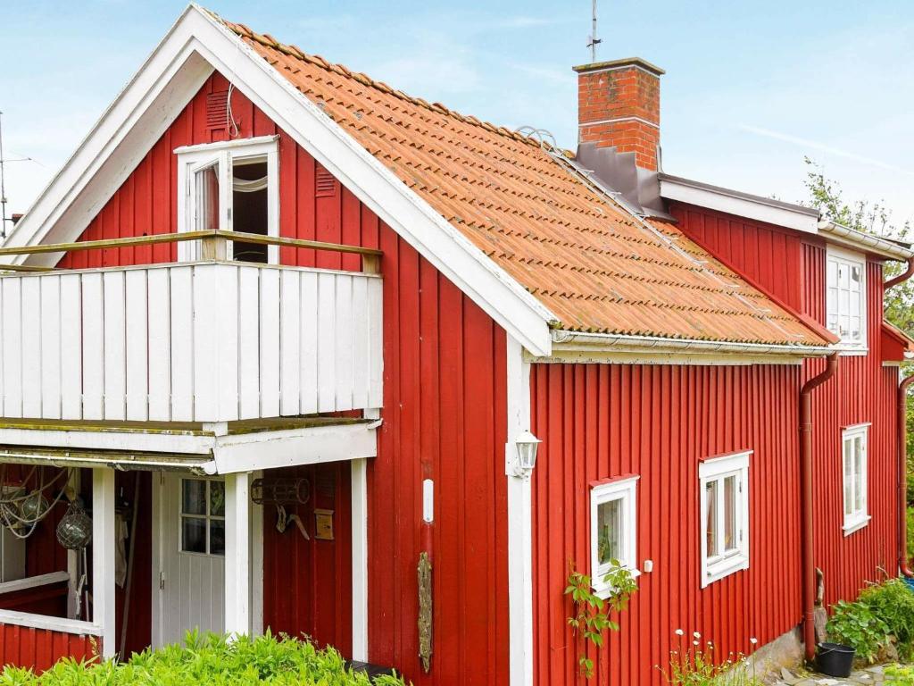 uma casa vermelha com um telhado laranja em 4 person holiday home in R nn ng em Rönnäng
