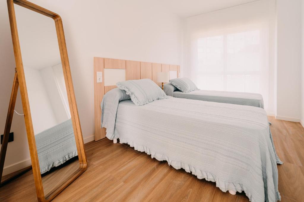 Posteľ alebo postele v izbe v ubytovaní Apartamentos Rúa Vella
