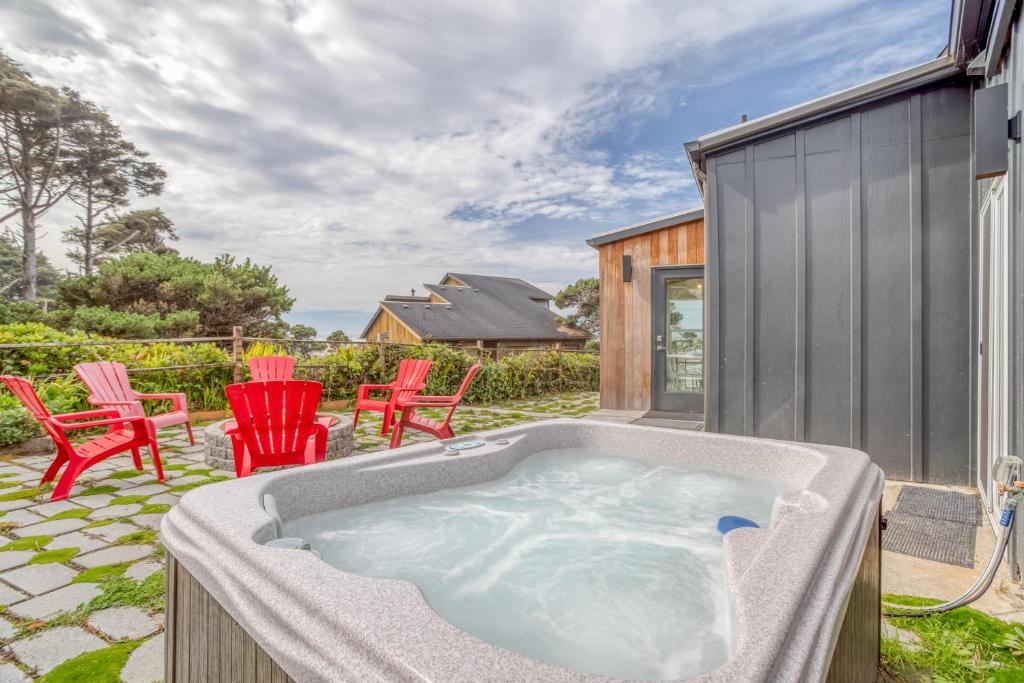 Un jacuzzi en un patio con sillas rojas. en Holiday Beach House, en South Beach