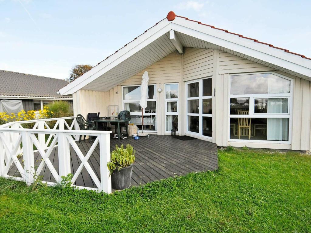 una casa con terraza de madera en el patio en 4 person holiday home in Gelting, en Gelting