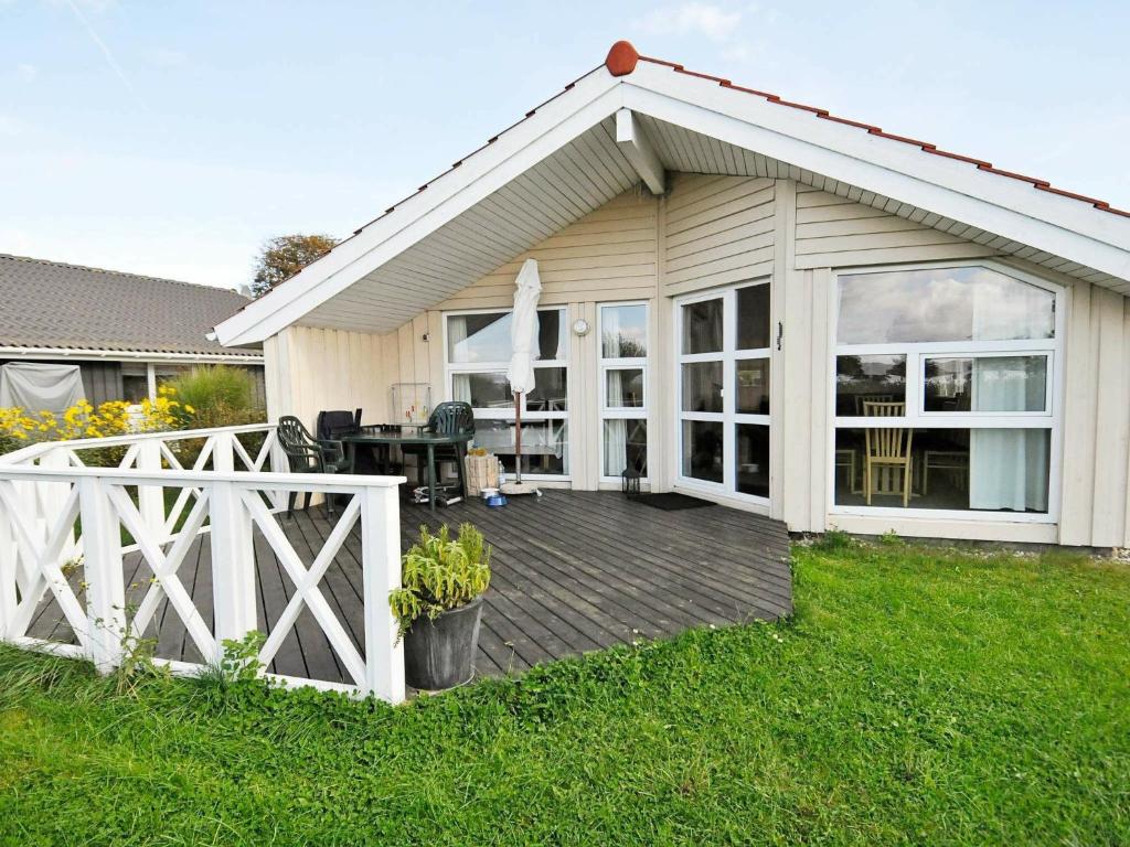 a house with a wooden deck in the yard at 4 person holiday home in Gelting in Gelting