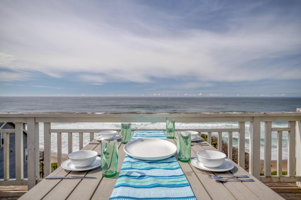 a table on a deck with a view of the ocean at The Driftwood in Depoe Bay