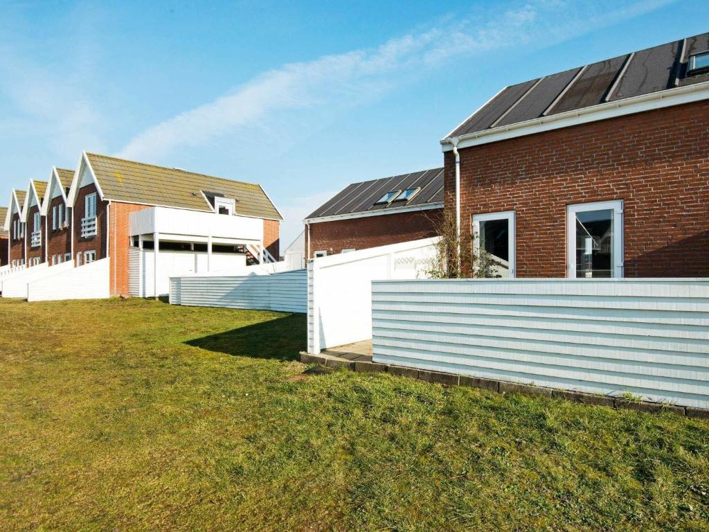 Une rangée de maisons et un bâtiment en briques dans l'établissement Three-Bedroom Holiday home in Rømø 39, à Rømø Kirkeby