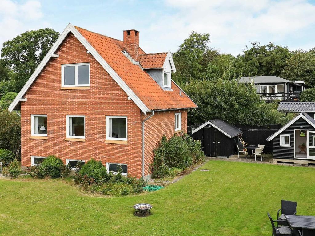 une grande maison en briques avec une cour d'herbe dans l'établissement 4 person holiday home in Ebberup, à Ebberup