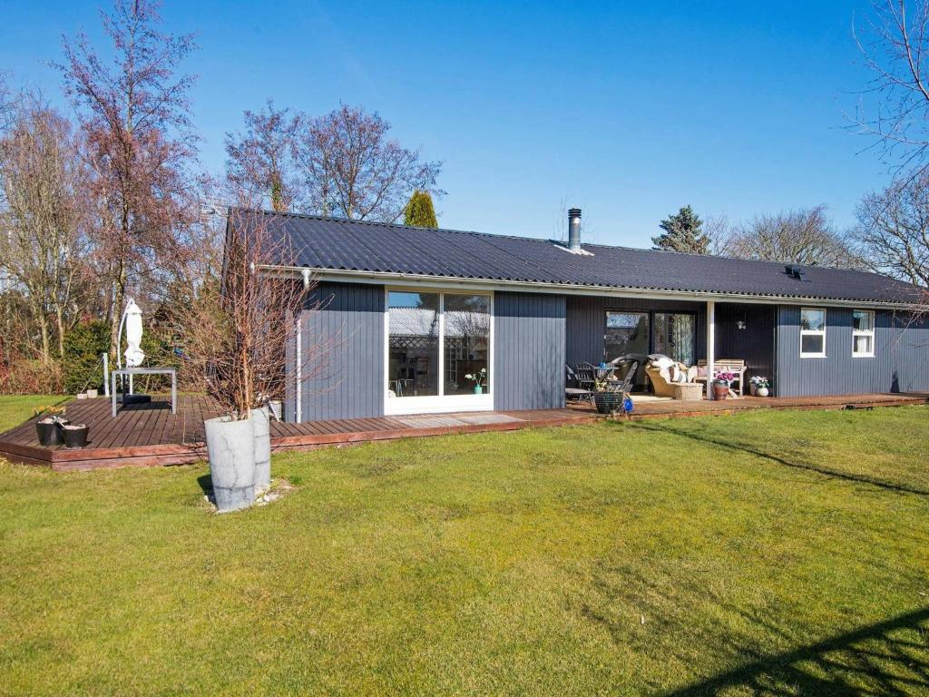 uma casa com um grande quintal em frente em 6 person holiday home in Odder em Norsminde