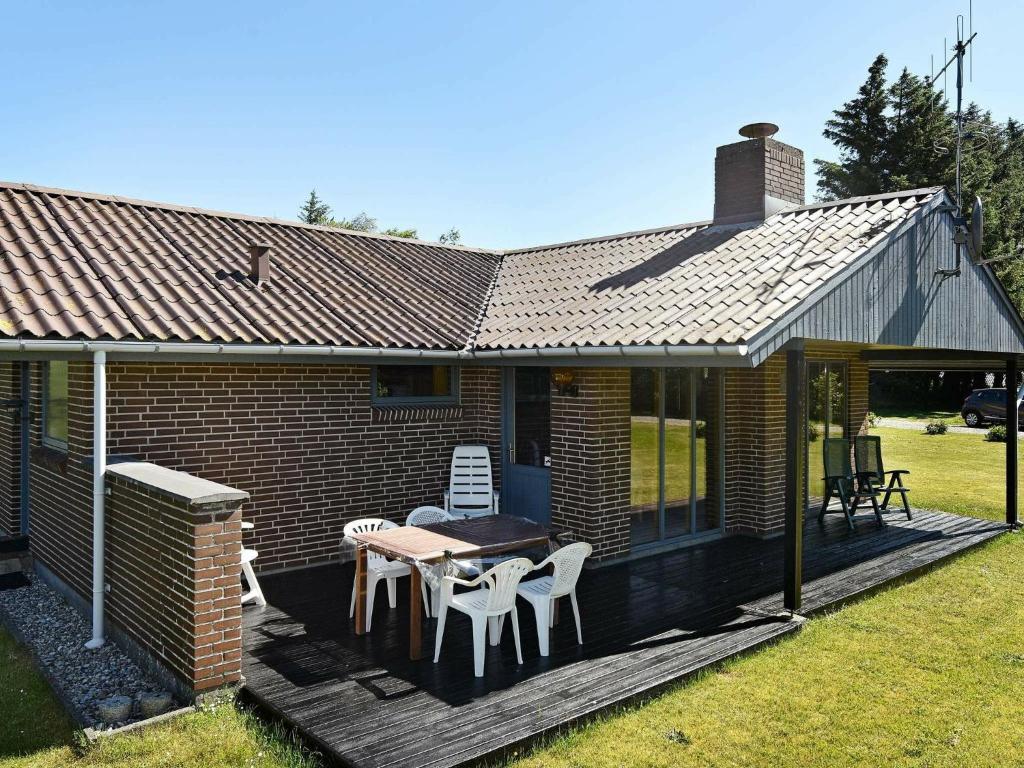 een huis met een terras met een tafel en stoelen bij 4 person holiday home in Henne in Henne Strand