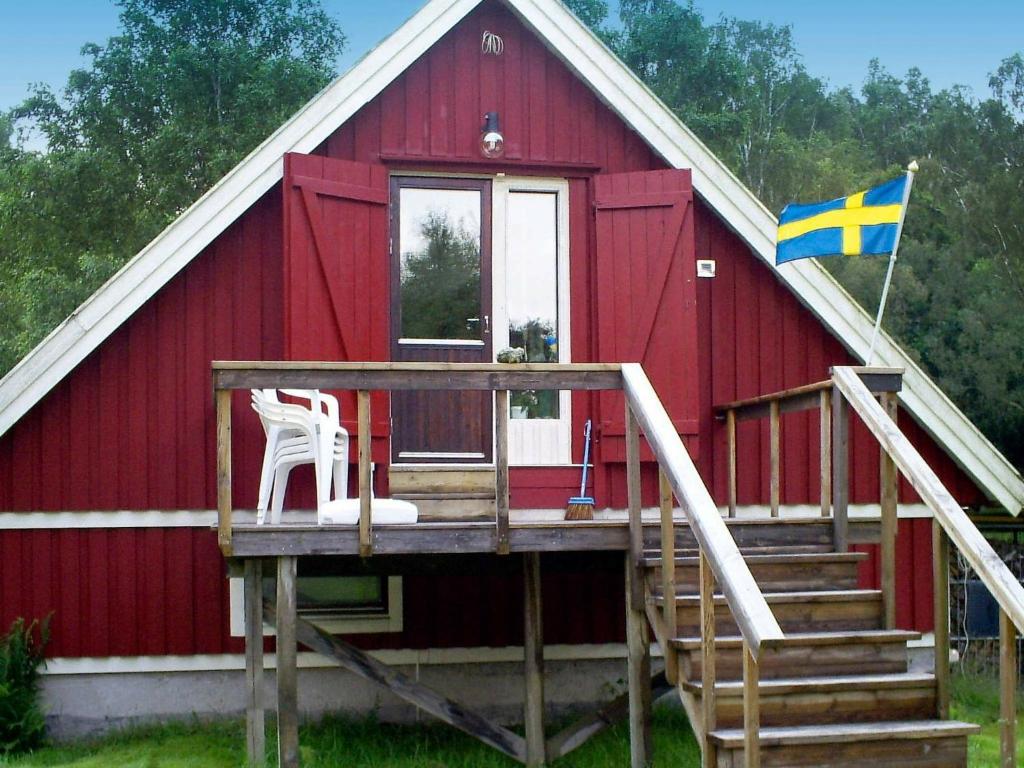 a red cabin with a flag and a flag at 6 person holiday home in ASKER N in Stenungsund