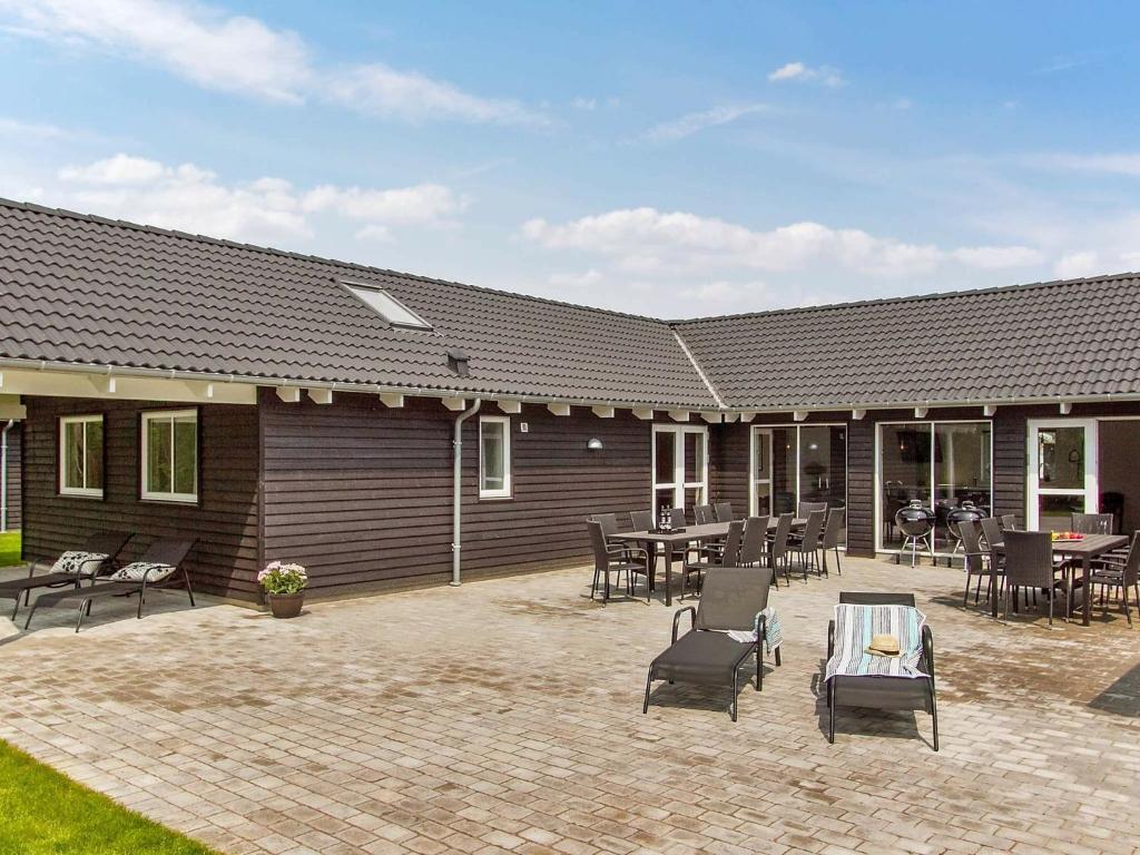 a patio with chairs and tables in front of a building at Holiday home Kappeln IX in Kappeln