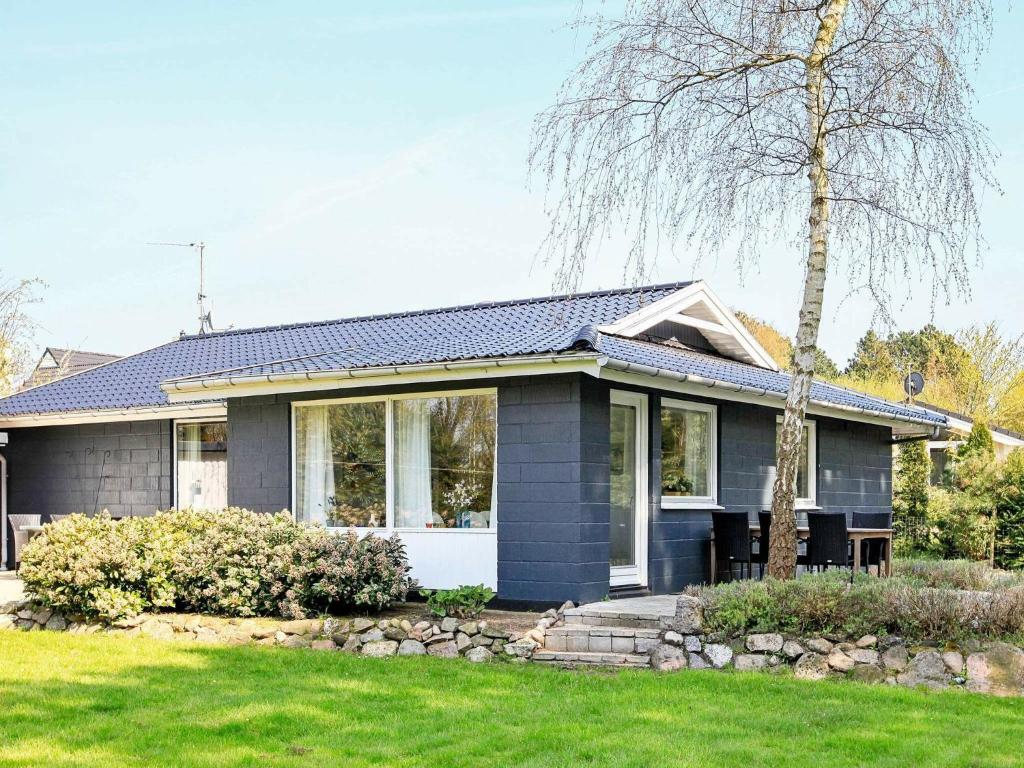 una casa con revestimiento azul y un patio en Three-Bedroom Holiday home in Millinge 1, en Millinge