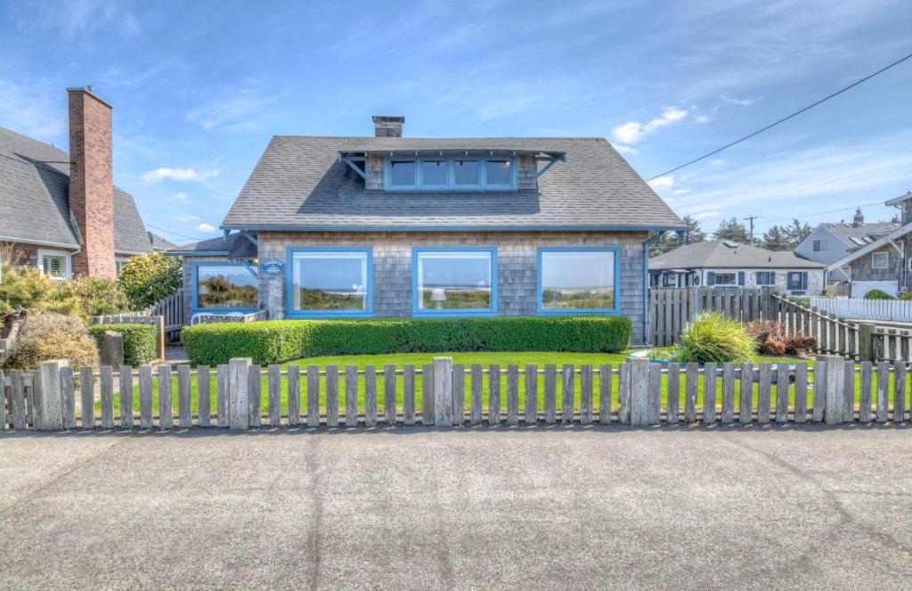 a house with a wooden fence in front of it at Byers Boathouse on the Prom - Meredith Lodging in Seaside