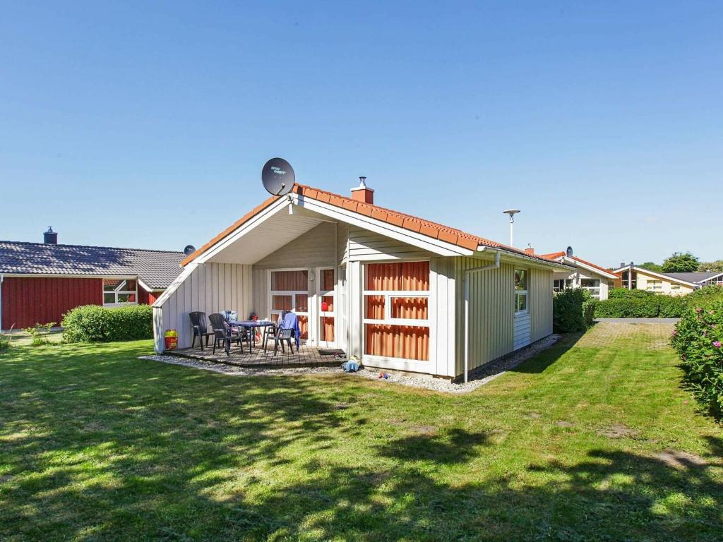 een klein huis met een patio en een tuin bij Three-Bedroom Holiday home in Grömitz 11 in Grömitz