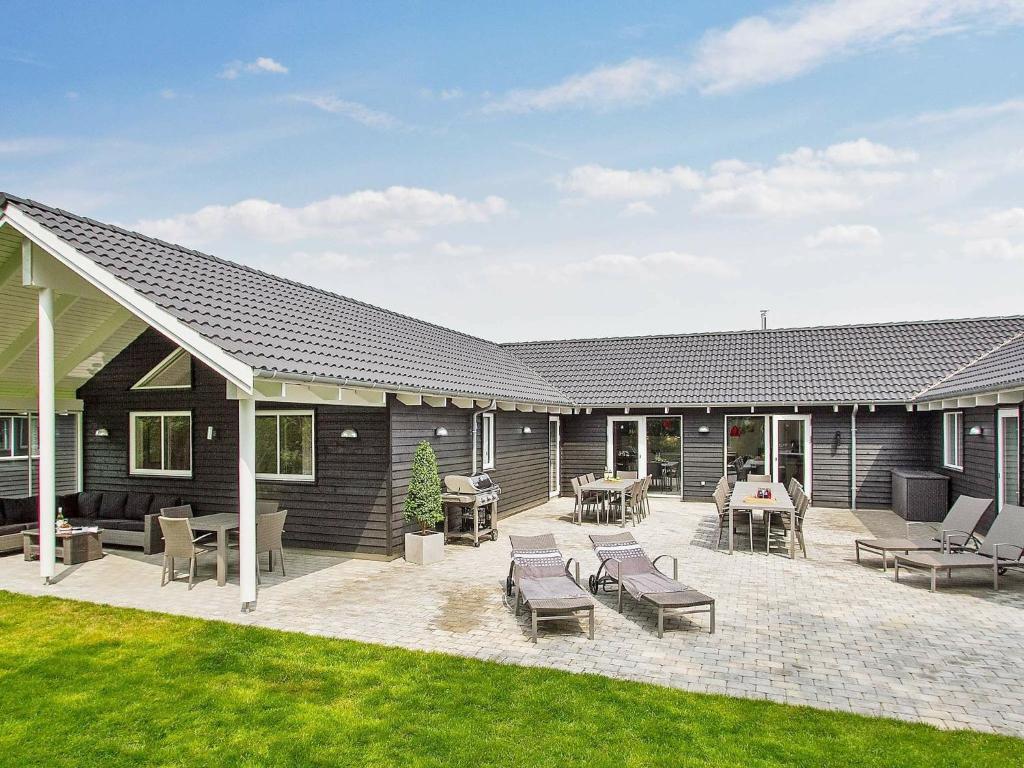 a house with a patio with chairs and tables at Holiday home Kappeln XIII in Kappeln