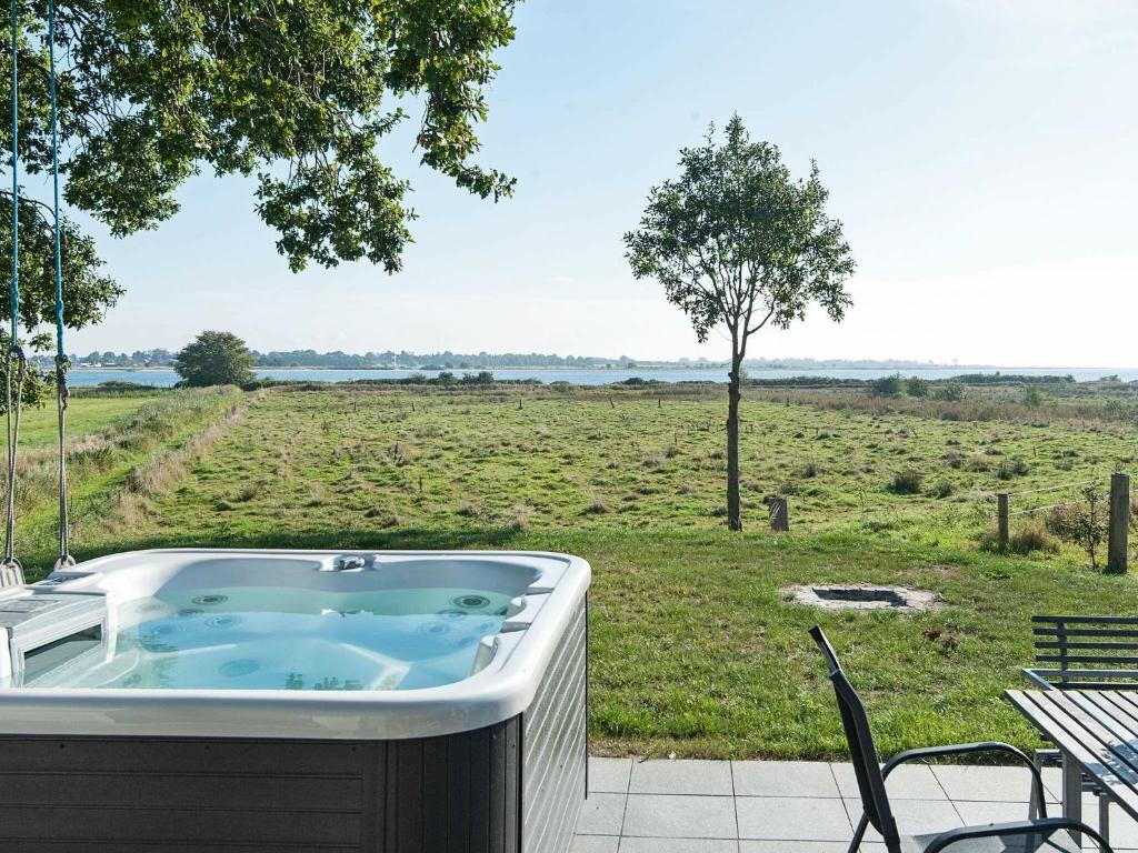 una bañera de hidromasaje en un patio con vistas a un campo en Holiday home Haderslev II, en Årøsund