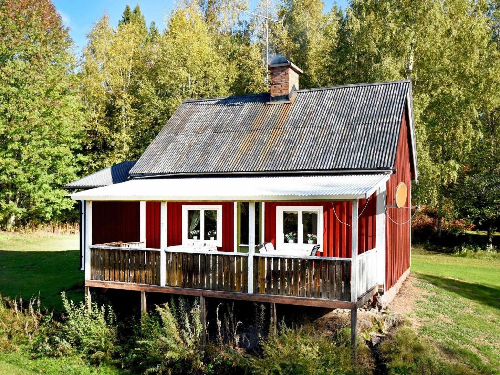 a red barn with a porch and a roof at 7 person holiday home in Sunnemo in Sunnemo