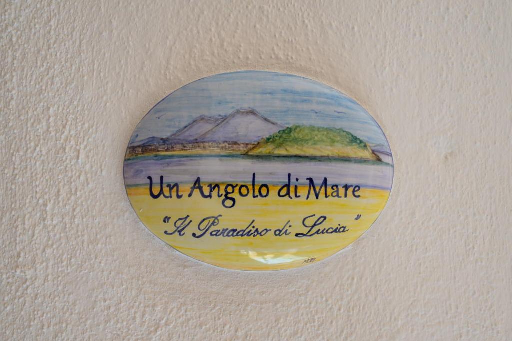 un cartel redondo en una pared con una pintura. en Un Angolo di Mare...nel centro di Ischia!, en Isquia