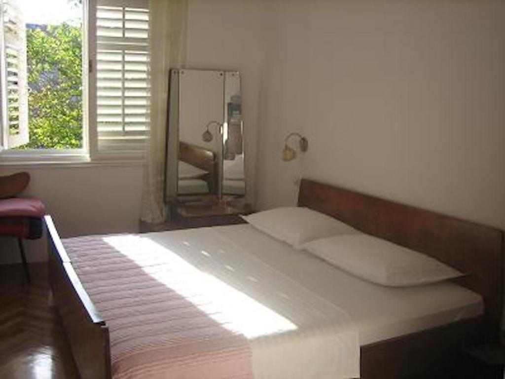 1 dormitorio con cama con espejo y ventana en Apartments Lucac Manus, en Split