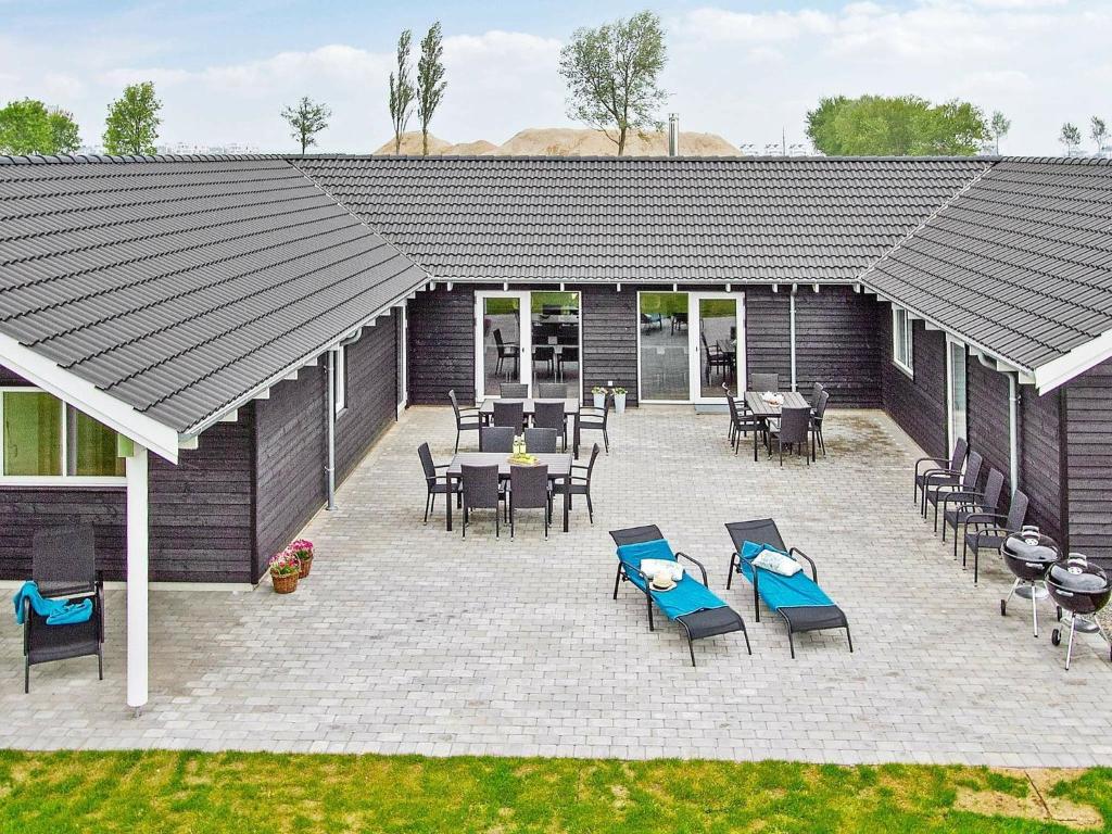 a patio with chairs and tables and a grill at 20 person holiday home in Hasselberg in Kappeln
